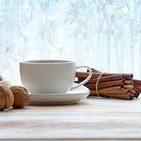 Fireplace wax warmer, sweater and cup of tea on a table